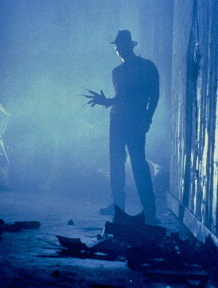 A scary man with knives for fingers looking down an alleyway.