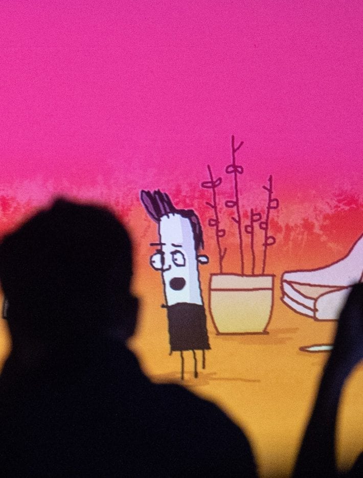 Silhouette of two figures watching animation of two people talking