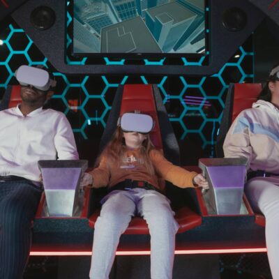 A group of three people of various ages wearing virtual reality headsets