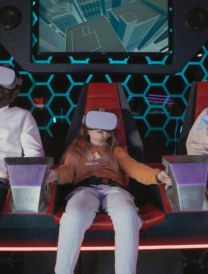A group of three people of various ages wearing virtual reality headsets